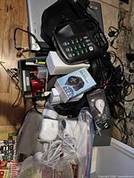 Overview of lot showing Arlo cameras, Acer laptop, Curtis phone, smartwatch box and cables