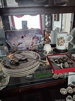 Overview of plates, tin, mug, bell, tumbler and box of spreaders