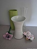 Group showing three vases, porcelain rose, pink floral pick
