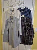 Four shirts hung on door showing front patterns and colours