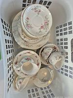 Mixed stack of saucers, plates and nested tea cups showing floral pattern