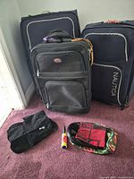 Front view showing black suitcase, two navy Nautica suitcases, pouches and lint roller