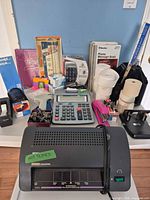 Full lot overview showing laminator, calculator, stapler, keypad and accessories