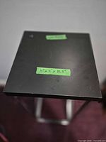Top view of black square table with dimension tape