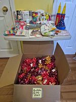 Overall view showing table of packaged items and open box of bows
