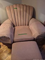 Front view of pink shell-back armchair with ottoman