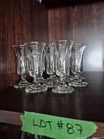 group of ten etched cordial glasses on shelf
