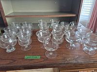 Set of 18 clear glass footed shrimp cocktail goblets on wooden surface