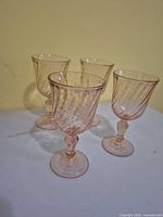 Four pink swirl wine glasses grouped on table