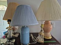 Group showing blue ceramic, peach ceramic, brass-glass column and crystal lamp bases with shades
