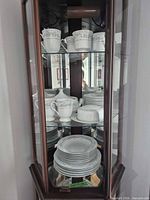Curio cabinet with full Somerset dinnerware set visible on three shelves