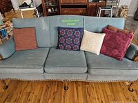 Full frontal view of blue-teal corduroy sofa showing overall style and wooden legs