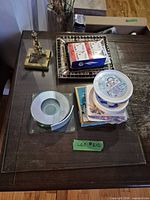 Group view showing brass ashtray, mirrored ashtray, glass coaster set, stack of assorted coasters