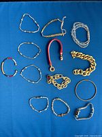 All 13 bracelets laid out showing styles and materials
