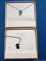 Boxed aventurine necklace above boxed black agate necklace