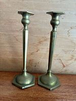 Front view of both brass candlesticks with hexagonal bases