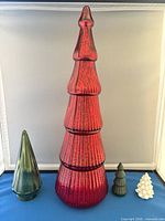 Group of four Christmas trees showing relative sizes and colors