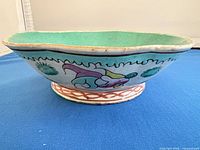 Side profile of pedestal bowl showing fish motif and foot design