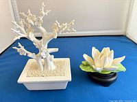Bonsai tree and lotus figurine side by side