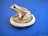 Top and side view of frog trinket box showing figurine and metal band