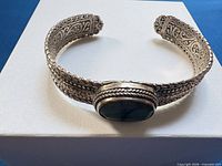 Front view showing turquoise stone and braided edging