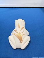 Back view showing gold cattail design on ivory porcelain frog
