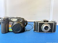 Front view of Nikon Coolpix 5400 and Kodak Flash Bantam cameras side by side