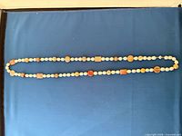 Full view of entire necklace laid flat showing length and bead pattern