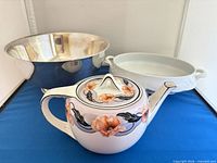 All three items grouped: teapot foreground, silverplate bowl left rear, white serving dish right rear