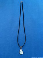 Full view of necklace showing cord, pendant, and clasp