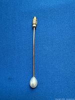 Full view of stick pin showing pearl tip and safety cap