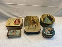 Five British royalty tins arranged side by side