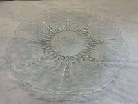 Overhead view of clear crystal plate showing full etched cornflower pattern and scalloped rim