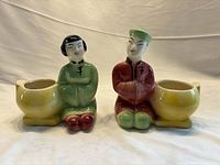 Front view of both ceramic boy and girl planters