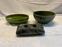 Three green glazed pottery pieces on display