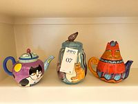 Front view of all three cat-theme ceramic pieces