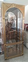 Full view of brass-tone glass curio cabinet