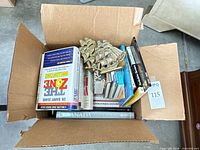 Box containing brass ship bookends and assorted books