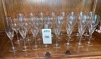 Group view of all 16 crystal glasses arranged on wooden surface