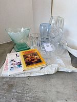 Group shot of four glass pieces and three books