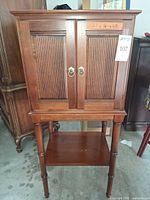 Front view of Ethan Allen cherry cabinet with doors closed