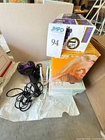 Hot Tools rollers box, Sylvania Sun Lamp box, purple/black handheld massager with cord