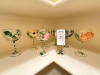 Eight hand-painted floral goblets arranged on shelf