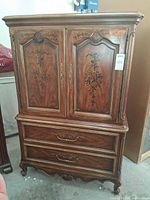 Full frontal view of armoire showing doors, drawers, legs