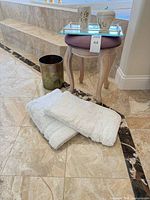 Group view of bath mats, waste basket, ceramics, tray on stool