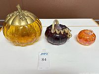 Front view of all three glass pumpkins showing colors, sizes and metal lid
