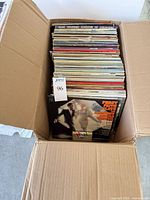 Open cardboard box showing full stack of LPs