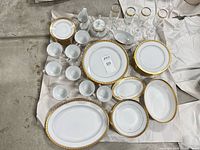 Full layout showing all china plates, bowls, platters, gravy boat, creamer, lidded sugar and stemmed glasses
