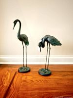 Pair of crane sculptures on wooden floor