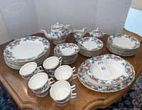 Full set laid out on table showing plates, cups, serving pieces